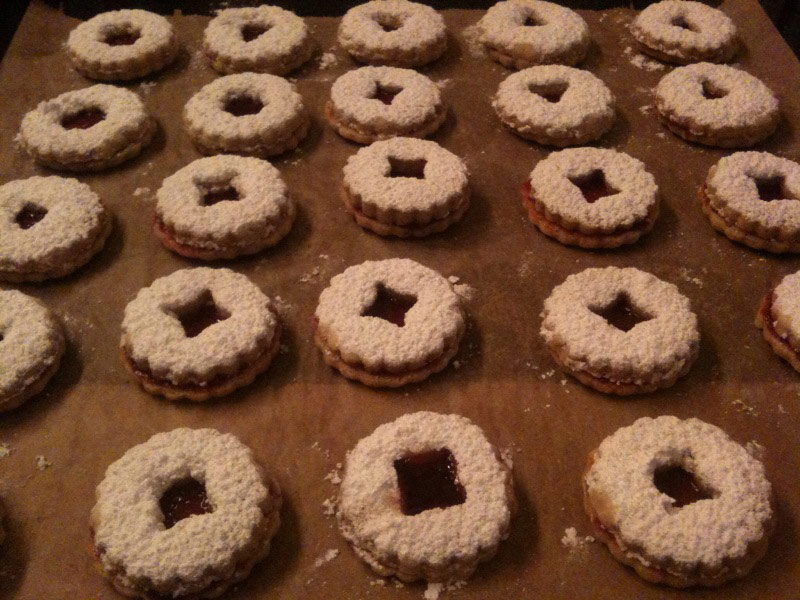 
Spread the jam mixture over the cookie circles and ut one dusted cookie ring on each of the cookie circles